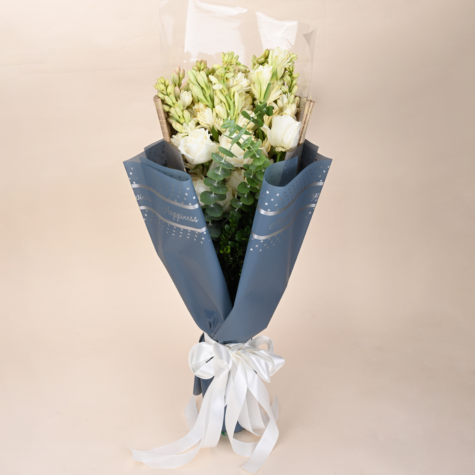 Ivory Tuberose Grace white rose and tuberose bouquet with eucalyptus, blue-grey wrap, and white ribbon by Rapid Petals by Yashken Fresh