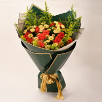 Coral Meadow Glow mixed flower bouquet in Bangalore with coral-red roses, yellow spray blooms, green fillers, dark green wrapping, and gold ribbon by Rapid Petals by Yashken Fresh
