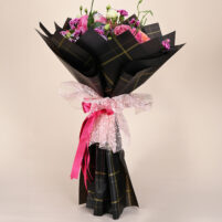Midnight Blush Bloom pink and purple bouquet with pink roses, peach roses, purple-edged blooms, magenta carnations, black wrap, and pink ribbon by Rapid Petals by Yashken Fresh