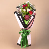 Ruby Blush Serenade red and pink flower bouquet with red gerbera, peach roses, baby’s breath, fresh greenery, pink and black wrap, and green ribbon by Rapid Petals by Yashken Fresh