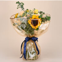 Sunlit Peach Garden sunflower bouquet with peach roses, yellow roses, white roses, eucalyptus greenery, golden wrap, and navy blue ribbon by Rapid Petals by Yashken Fresh
